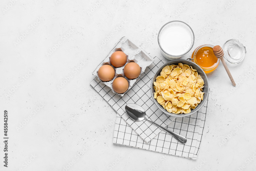 Ingredients for tasty breakfast with cornflakes on light background
