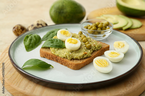 Tasty sandwich with guacamole, eggs and peas on table, closeup