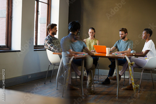 Casual business people meeting in circle in sunny office