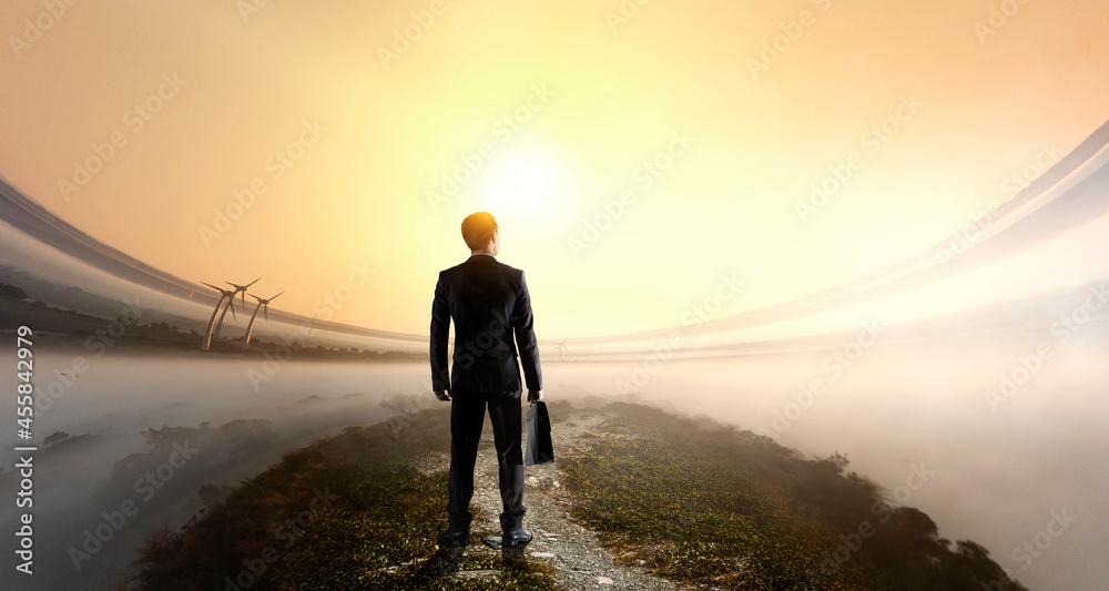 Businessman standing in front of landscape . Mixed media