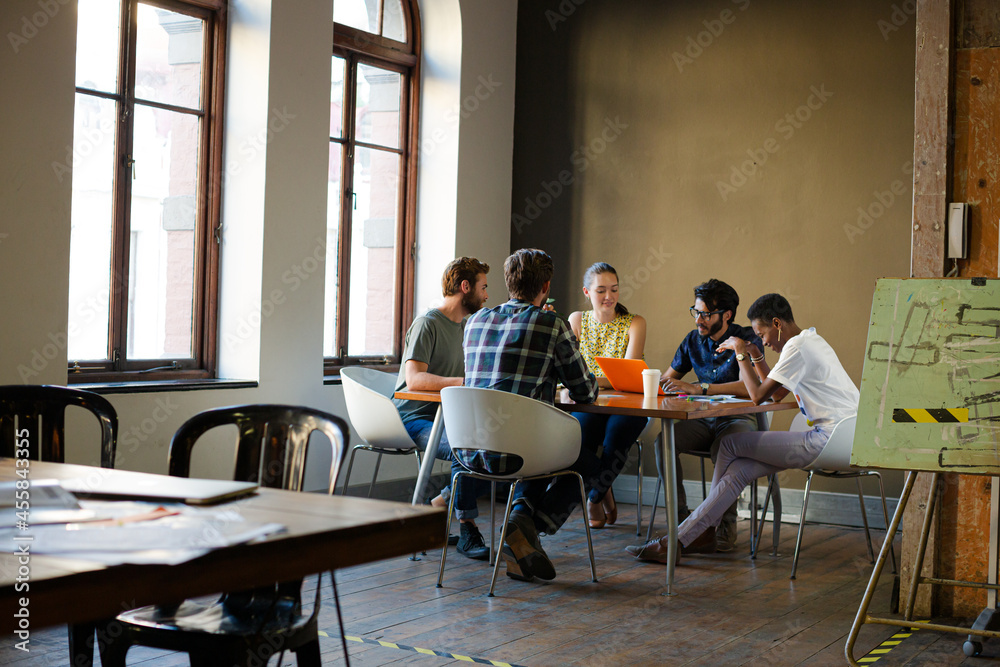 Fototapeta premium Creative business people working at tables in sunny office
