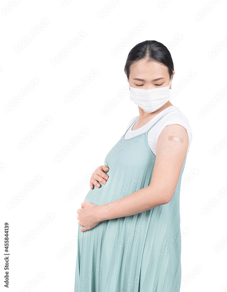 Vaccinated pregnant woman looking plaster bandage on arm after getting Covid-19 vaccine injection. Vaccinated pregnant woman looking plaster bandage on arm after getting Covid-19 vaccine injection.