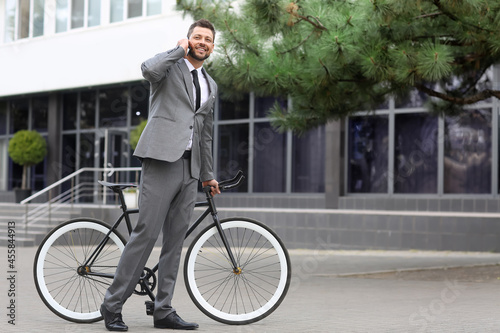 Businessman with bicycle an...