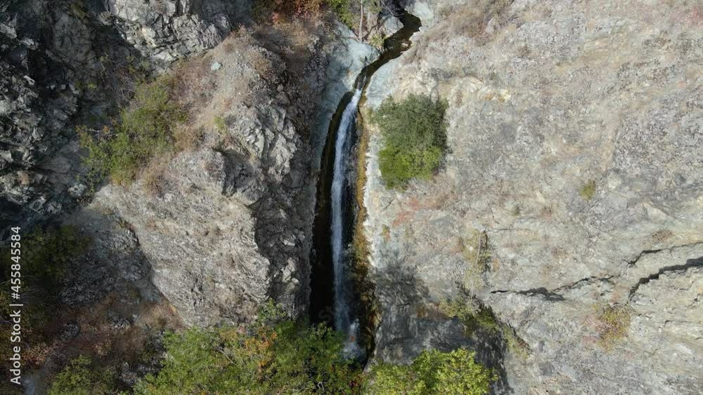 Aerial view away from a waterfall in the mountains of sunny Cyprus - tilt, drone shot Aerial view away from a waterfall in the mountains of sunny Cyprus - tilt, drone shot
