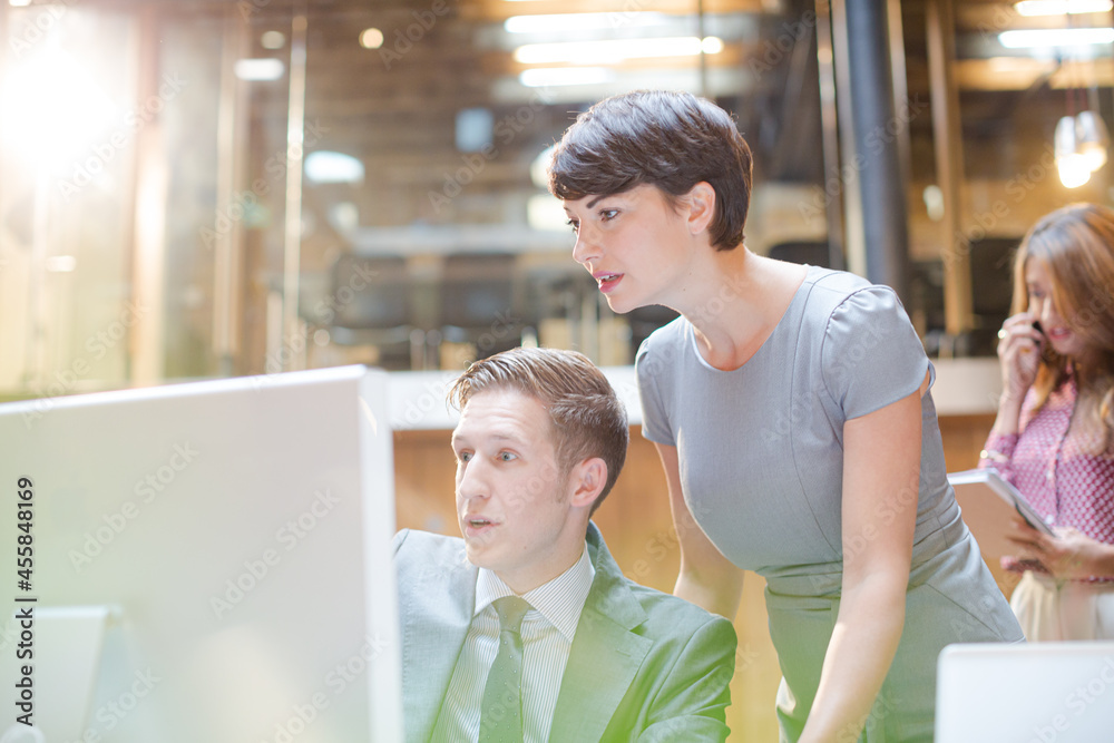 Businessman and businesswoman using computer in office Businessman and businesswoman using computer in office