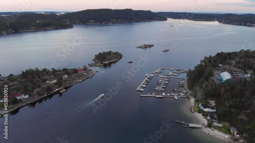 Idyllic location with beach, dock and summer cabins in Kragerofjorden; golden hour photo