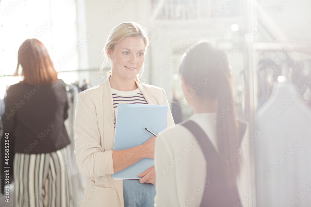 Fashion designer instructing assistant Fashion designer instructing assistant