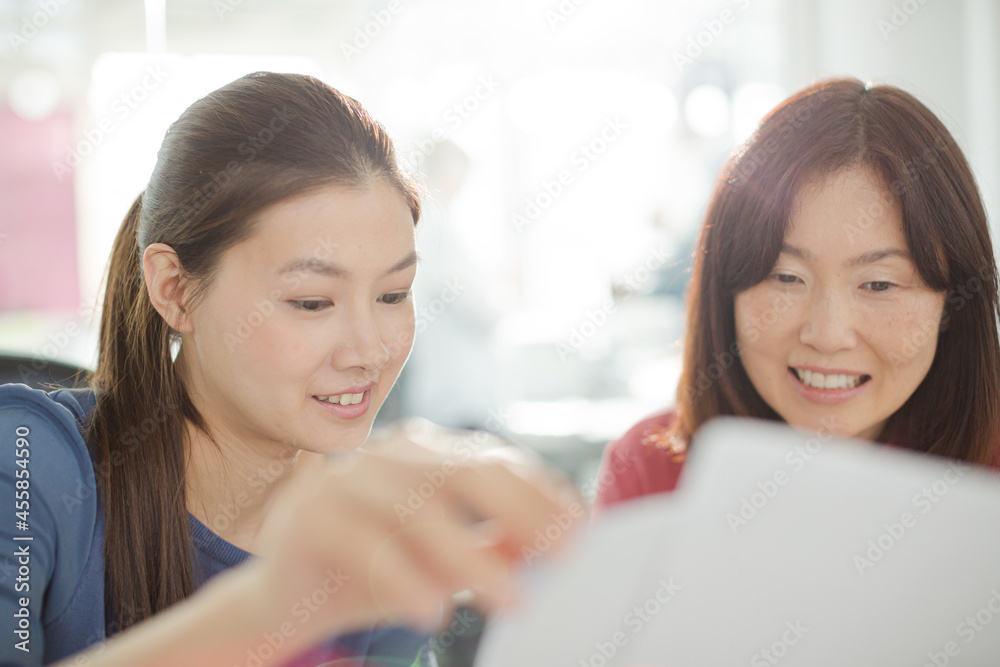 Businesswomen discussing paperwork in office Businesswomen discussing paperwork in office