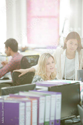 Fashion designers talking at desk in office