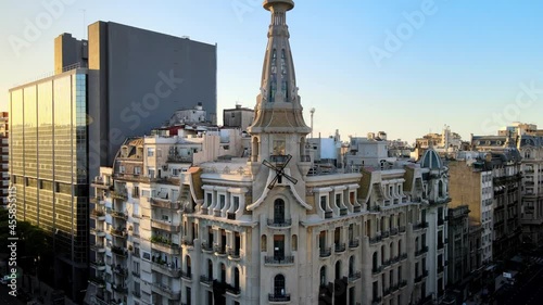 Aerial pan shot capturing the art nouveau style building exterior, Confiteria del Molino, reveals the big bright sun shimmering on Rivadavia avenue in Buenos Aires, Argentina. photo