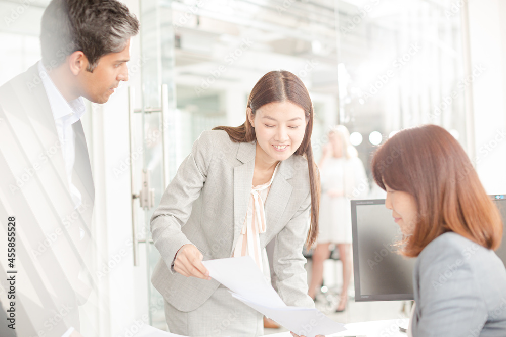 Fototapeta premium Business people reviewing paperwork at desk in office