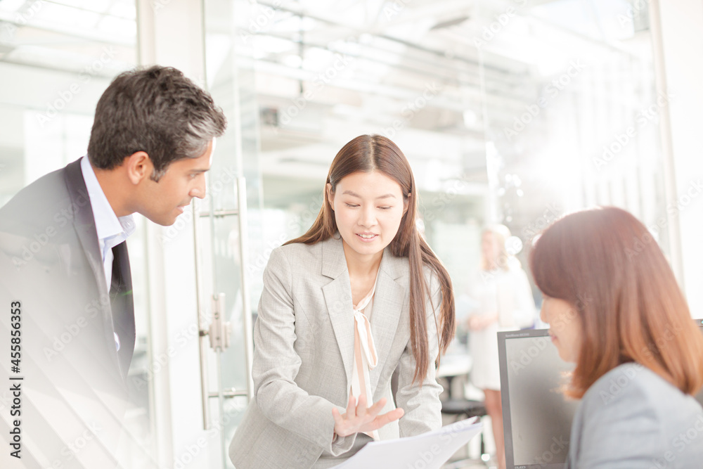 Fototapeta premium Business people reviewing paperwork at desk in office