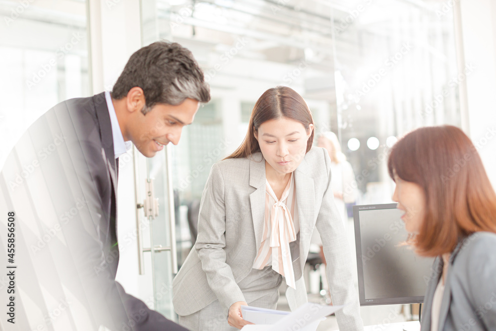 Obraz premium Business people reviewing paperwork at desk in office