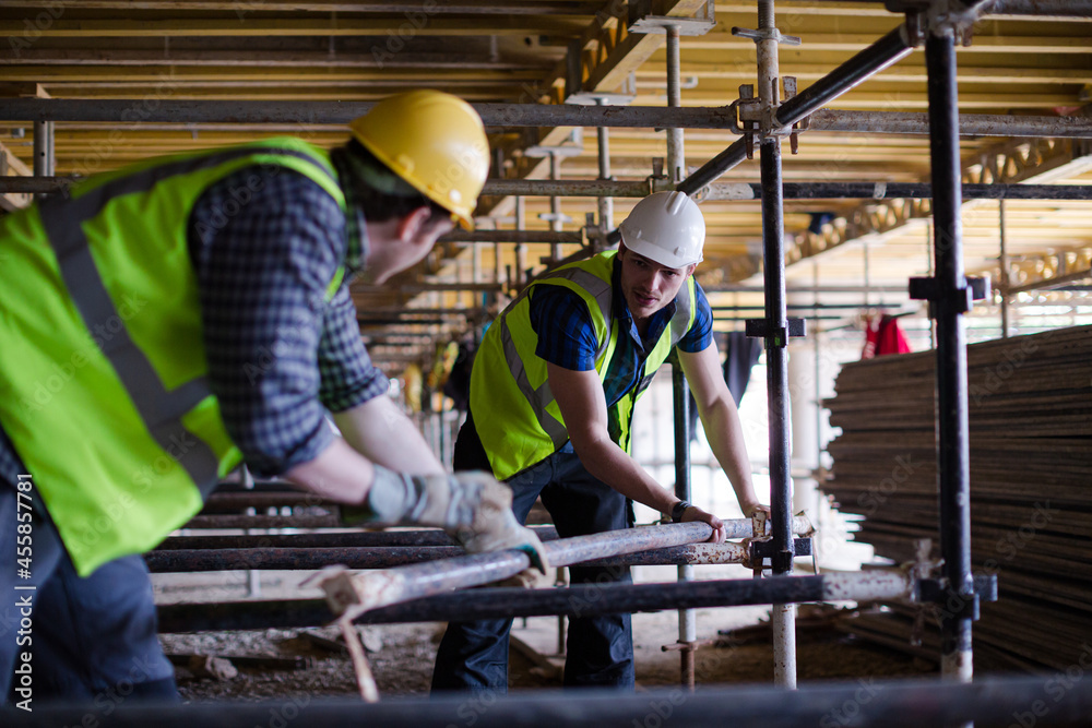 Constructor workers assembling rebar structure at construction site Constructor workers assembling rebar structure at construction site