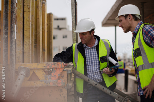 Construction worker engineer digital tablet talking at construction site
