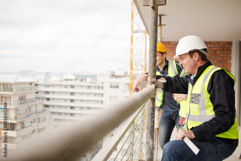 Construction workers talking at highrise construction site Construction workers talking at highrise construction site