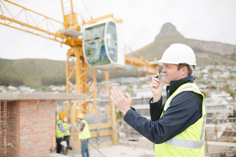 Construction worker with walkie-talkie at construction site Construction worker with walkie-talkie at construction site