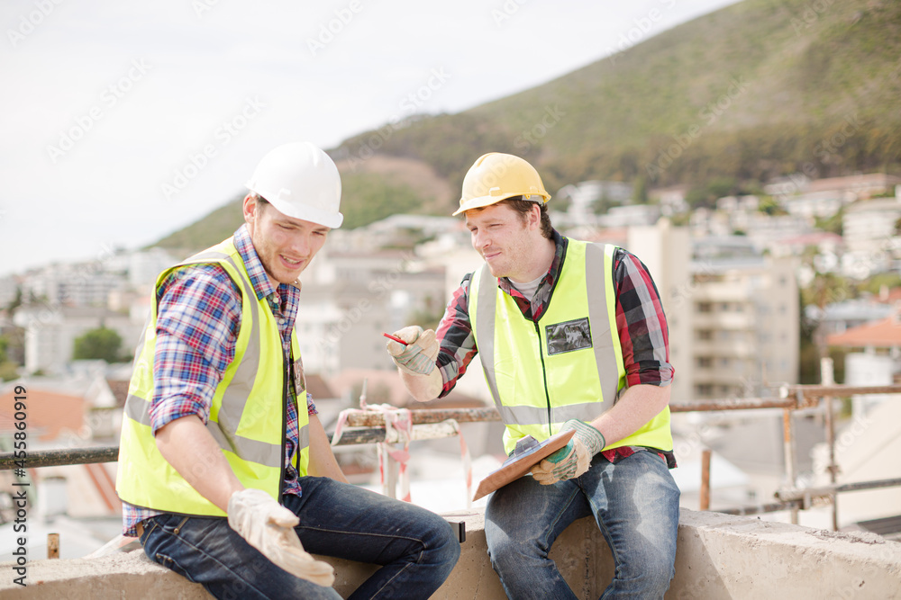 Construction worker engineer clipboard talking at highrise construction site Construction worker engineer clipboard talking at highrise construction site