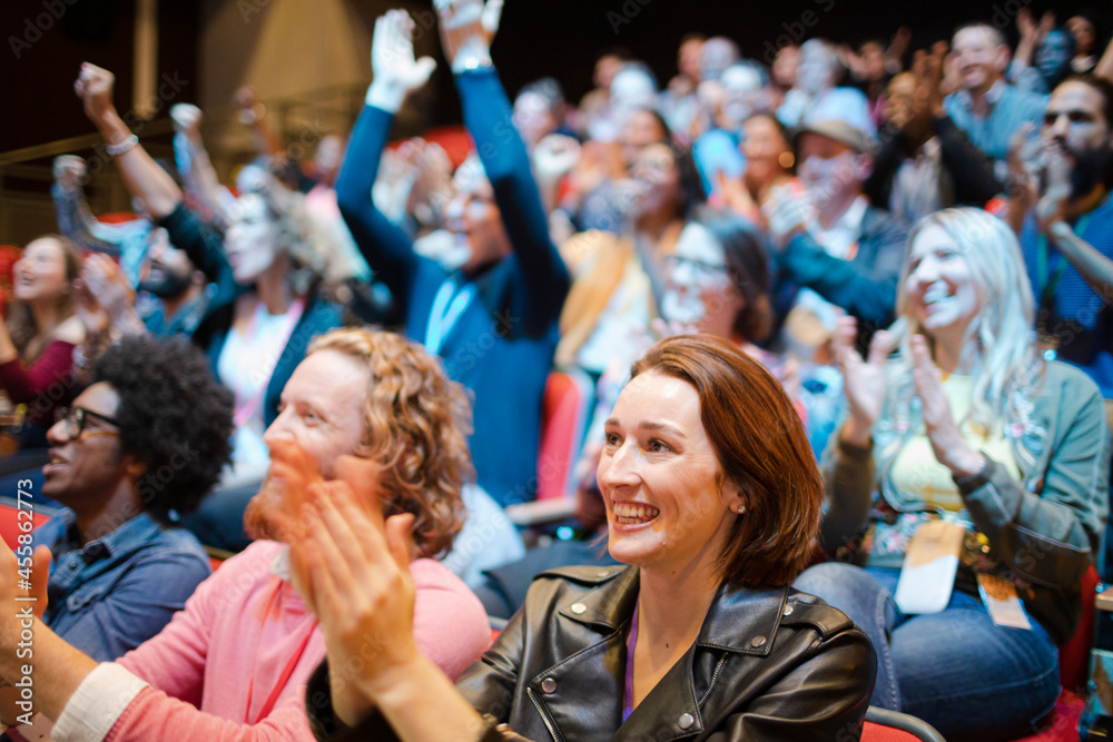 Smiling, excited audience cheering