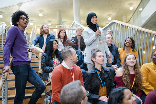 Woman in audience asking question photo