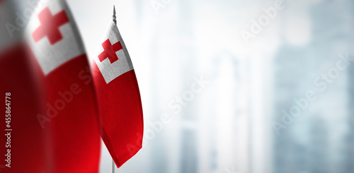 Small flags of Tonga on a blurry background of the city