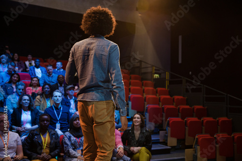 Male speaker on stage talking to audience