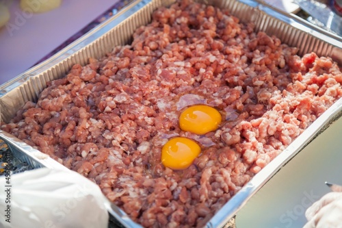 Minced meat and raw egg in a container.