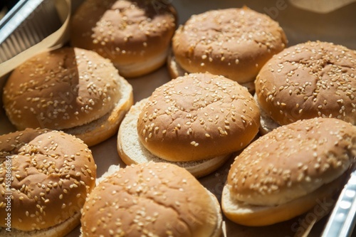 Fresh homemade burger buns on a tray.