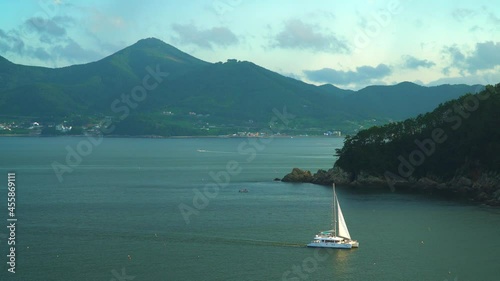 Picturesque Scenery Of Geoje Island With Luxury Catamaran Yacht Sailing Near Hanwha Resort Geoje Belvedere In South Korea. - Wide Shot photo