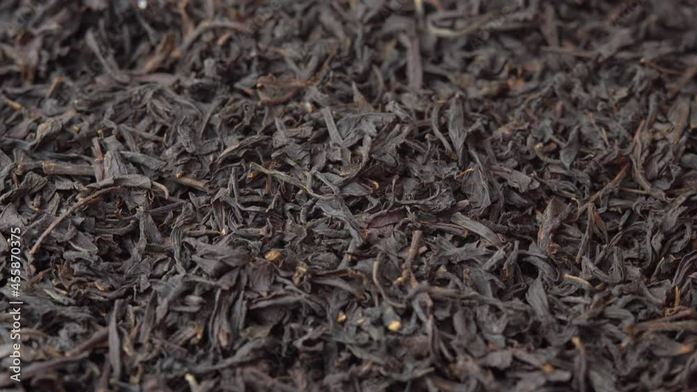 Black loose leaf tea spinning close up on plate, tea advertising, background for a cafe or restaurant black tea Black loose leaf tea spinning close up on plate, tea advertising, background for a cafe or restaurant black tea