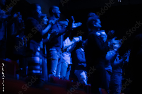 Audience clapping in dark room © KOTO
