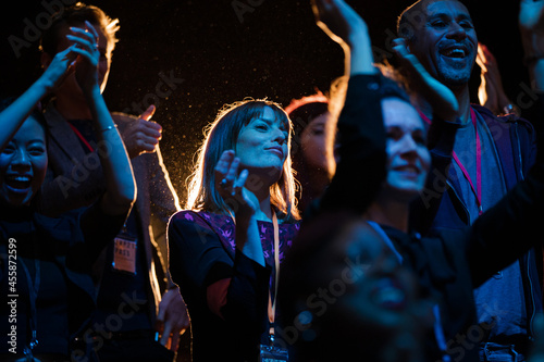 Konstfotografi Audience clapping and cheering in dark concert hall