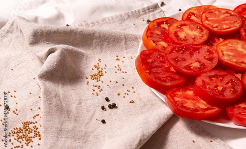 Plate with chopped tomatoes on a linen towel. 
