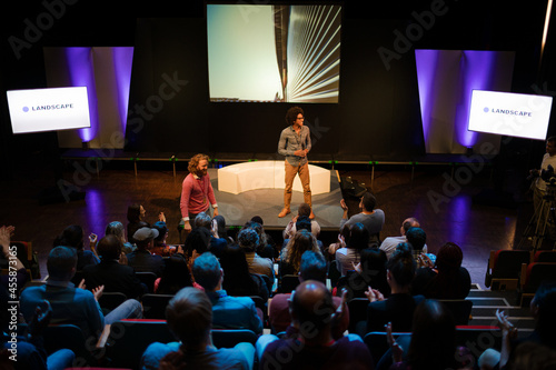 Audience watching speakers talking on stage