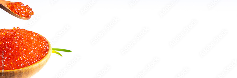 Red caviar in a wooden cup on a white background with a spoon and green onions. A large pile of bright caviar. Fresh delicious caviar. Isolated. A place for advertising, logo, label, layout, mockup. Red caviar in a wooden cup on a white background with a spoon and green onions. A large pile of bright caviar. Fresh delicious caviar. Isolated. A place for advertising, logo, label, layout, mockup.