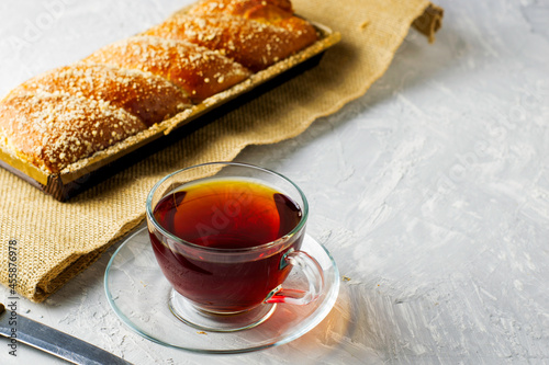 cherry-vanilla strudel knife and a cup of tea on a light gray surface