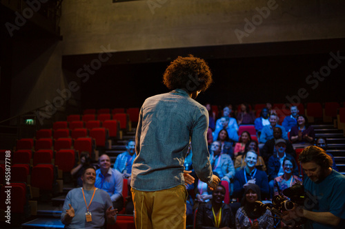 Male speaker on stage talking to audience