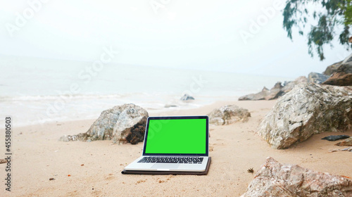 laptop on the beach, keylight green background.