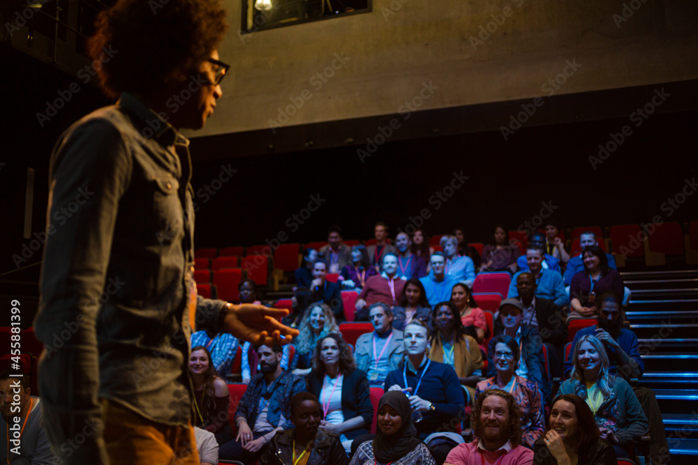 Male speaker on stage talking to audience