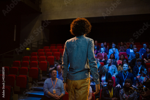 Male speaker on stage talking to audience