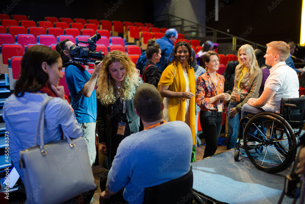 Audience talking to speakers in wheelchairs on stage