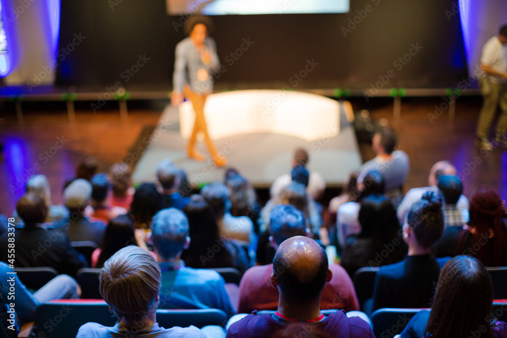 Naklejka premium Male speaker with microphone talking to audience