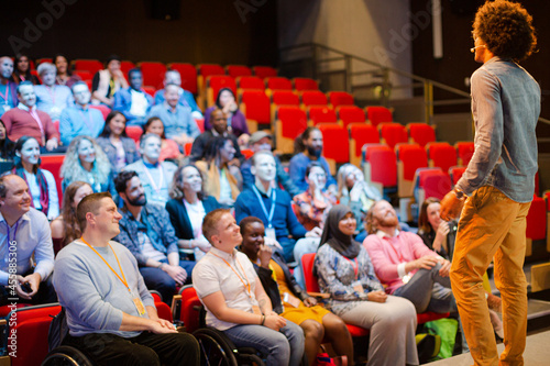 Audience watching male speaker on stage