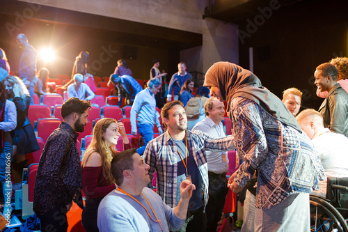 Female speaker in hijab on stage talking to audience © KOTO