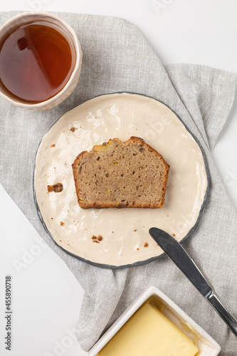 A slice of banana bread with tea and butter