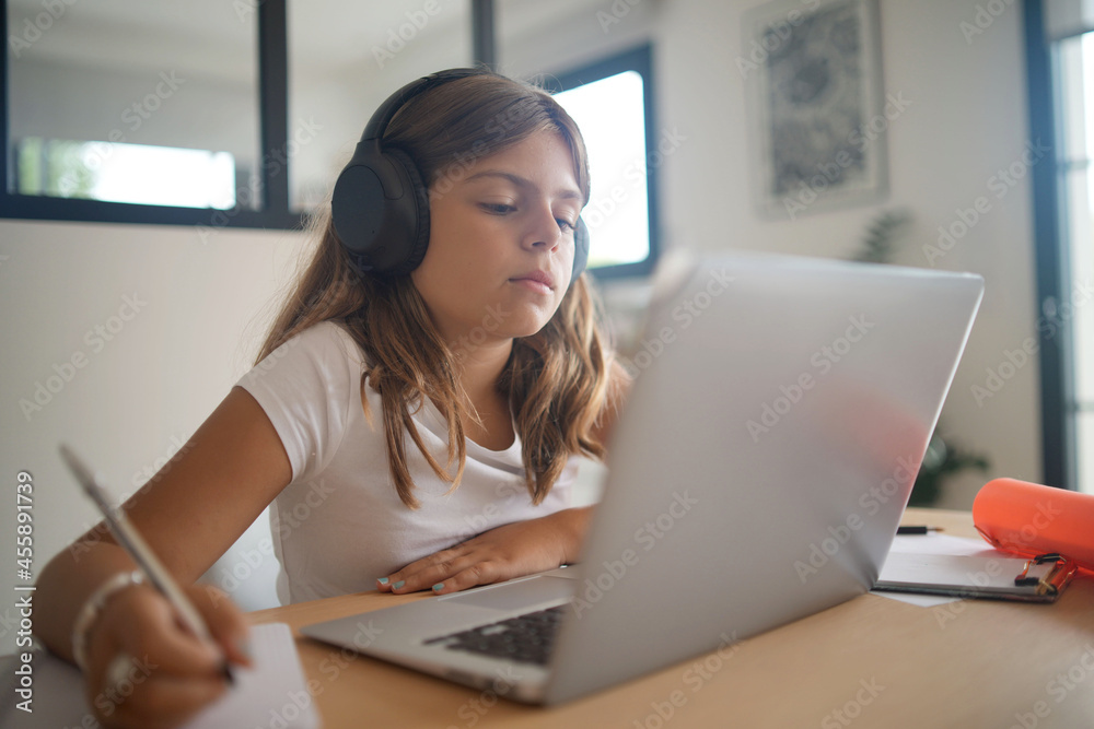 young girl on a laptop computer doing her lessons at home young girl on a laptop computer doing her lessons at home