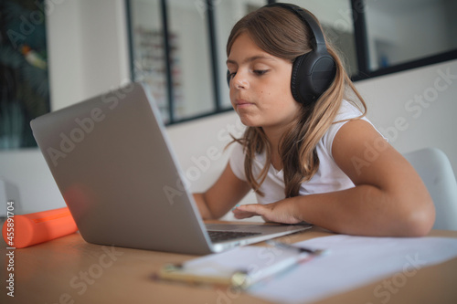 young girl on a laptop computer doing her lessons at home