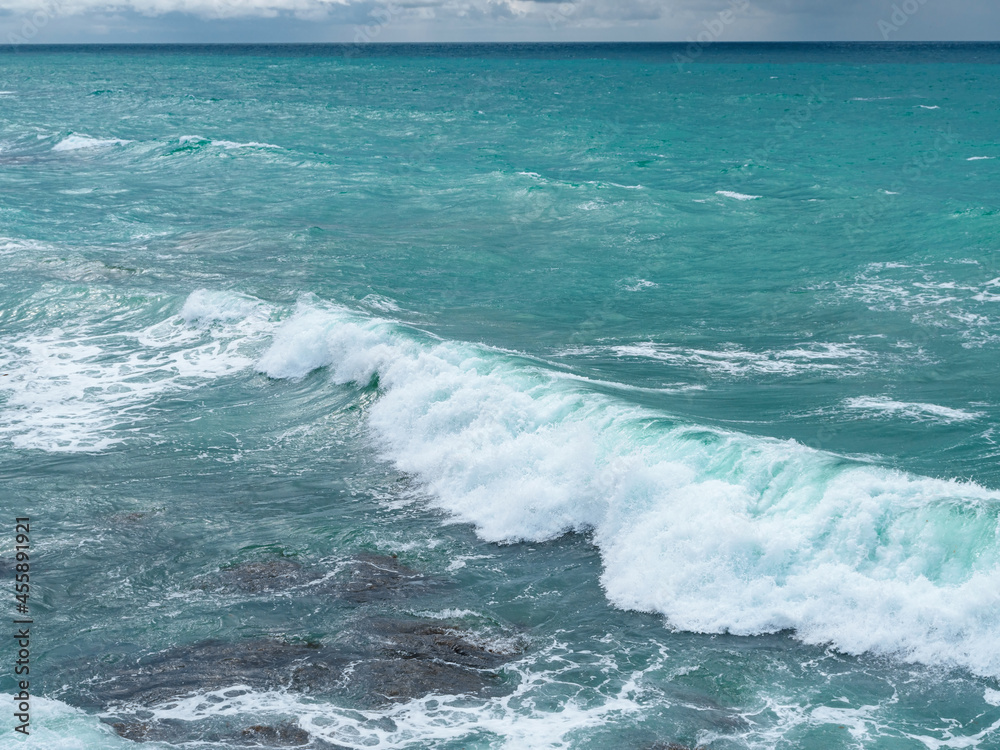 Fototapeta premium Beautiful view of ocean waves and a fantastic rocky shore, Sea patterns, background wallpaper.