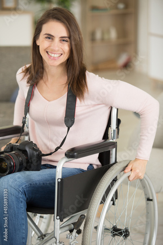 wheelchair bound woman at home holding a camera photo