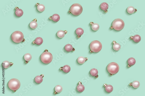 Pink Christmas balls isolated on light green background
